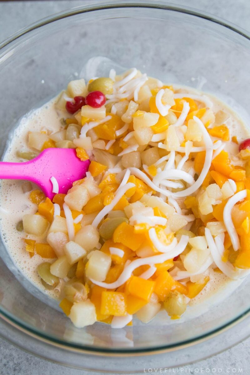 drained canned fruit and sweet cream in a large bowl about to be mixed together.