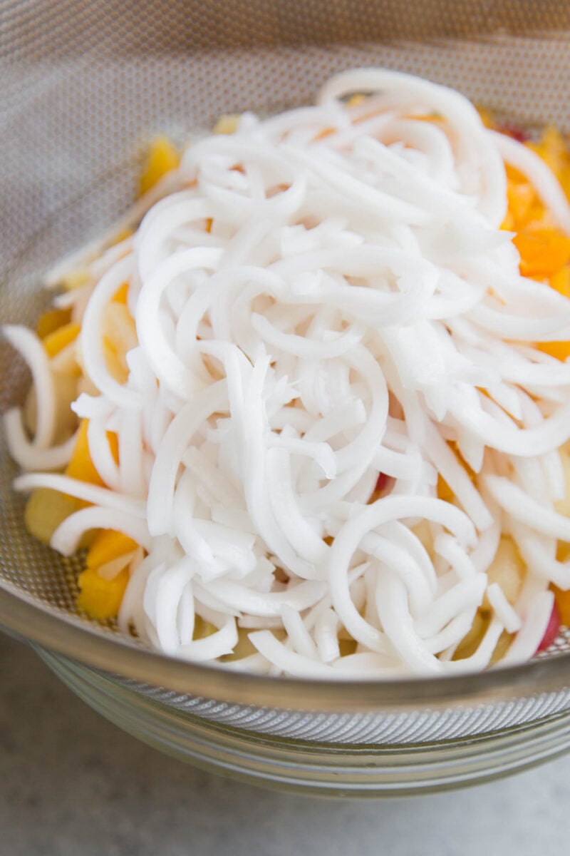 canned shredded young coconut draining in colander.