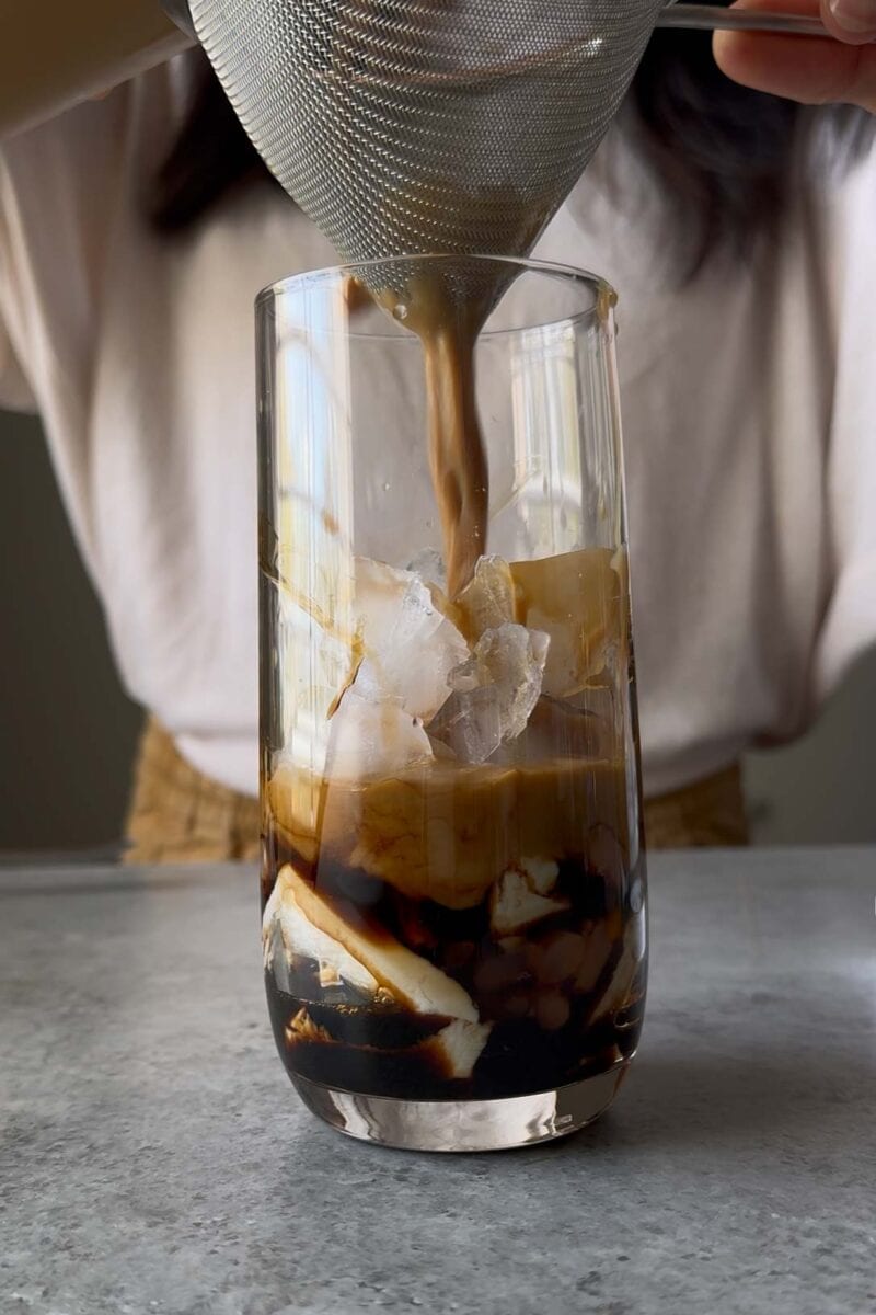 pour coffee mixture over strainer into prepared drinking glass.
