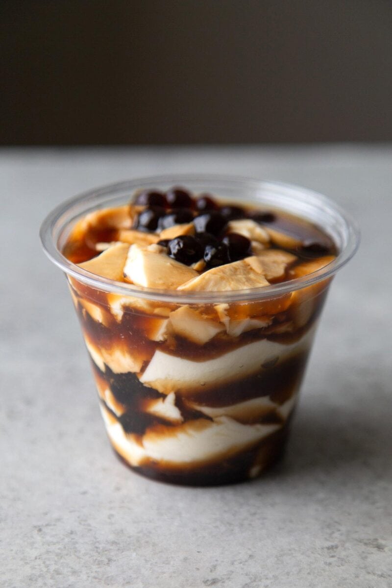 silken tofu and brown sugar tapioca layered in plastic cup.
