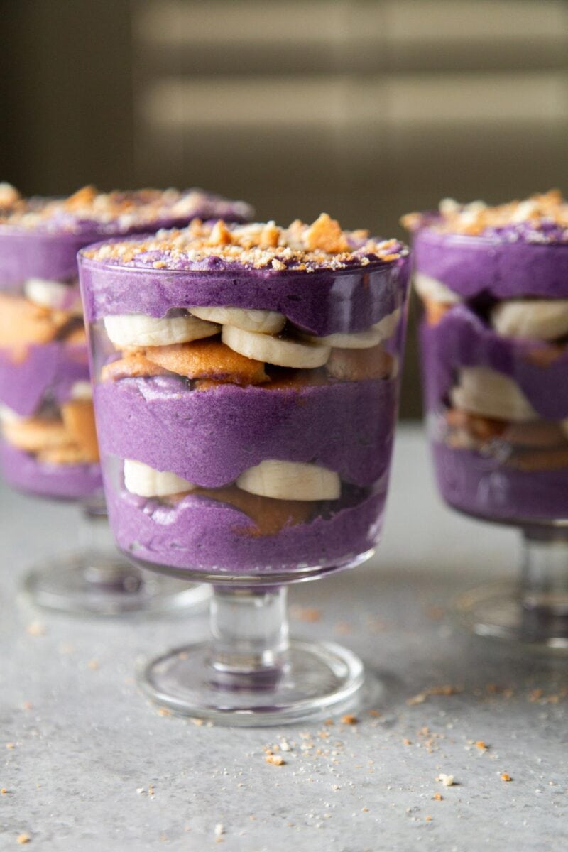 coconut ube pastry cream layered with Nilla cookies and fresh bananas in steamed glassware.