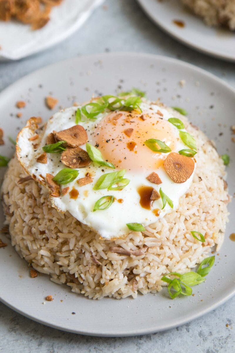 pork adobo fried rice garnished with fried egg, scallions, and Maggi seasoning.